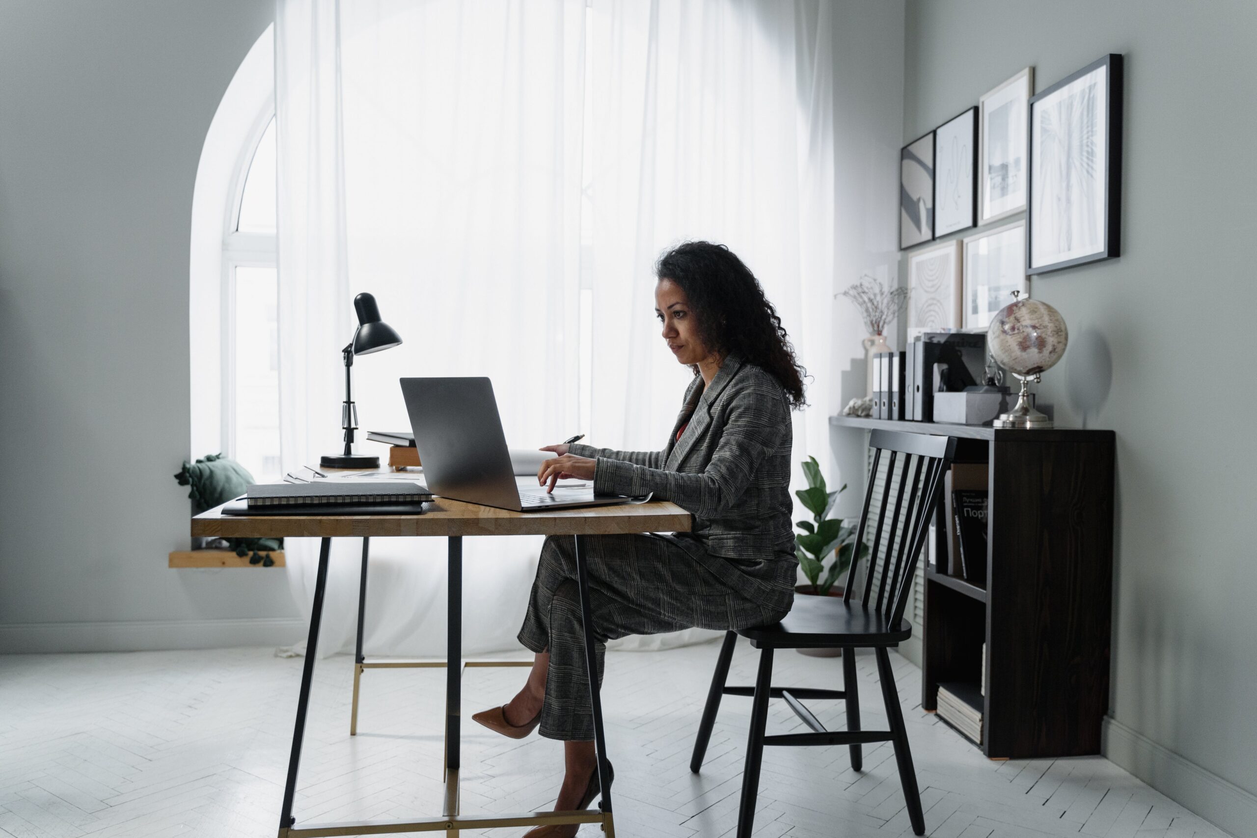 パソコンデスクに座って作業をする女性のイメージ